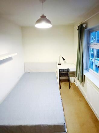Bright, simply furnished single bedroom with a ...