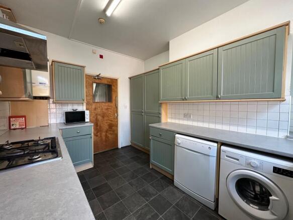 Bright, well-kept galley kitchen with sage-gree...