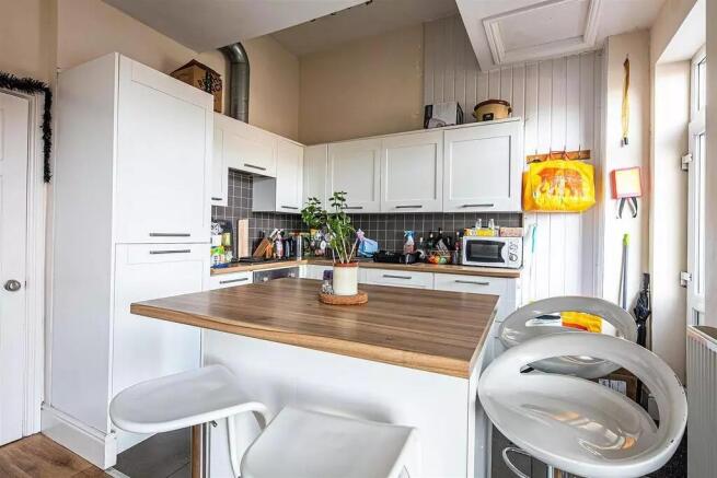 Bright and modern kitchen featuring white cabin...