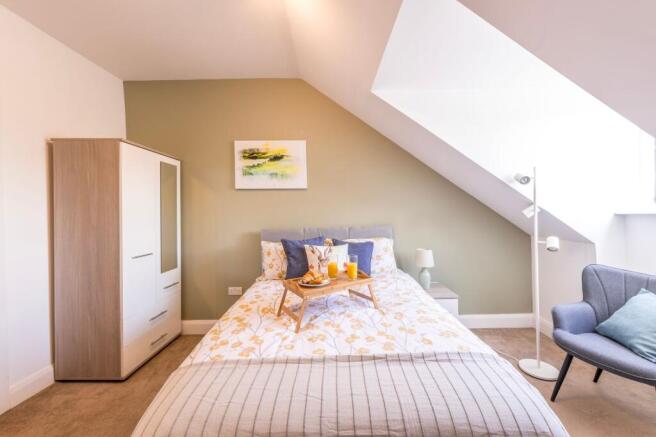 Bright, neatly styled double bedroom with a com...