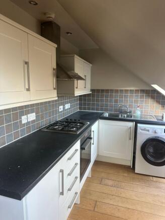 Modern fitted kitchen with dark worktops, integ...
