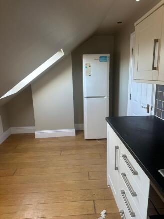 Bright kitchen area with angled skylight, moder...