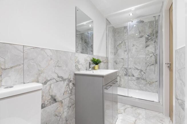 Modern bathroom with marble-effect tiles, a wal...