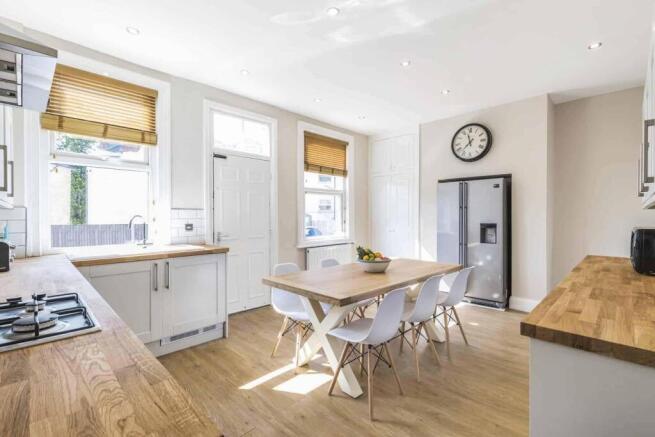 Bright modern kitchen with wooden worktops, a c...