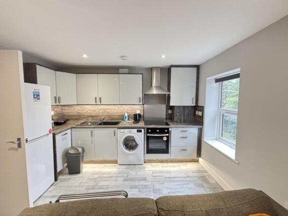 Bright open-plan kitchen with modern white cabi...