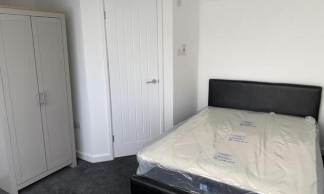 Neatly presented bedroom with a double bed, fit...