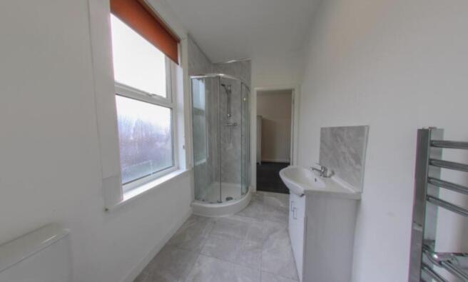 Bright modern bathroom with a corner glass show...