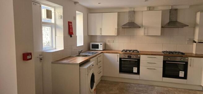 Bright, modern kitchen with matching white cabi...