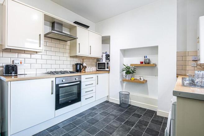 Bright modern kitchen with white cabinets, wood...