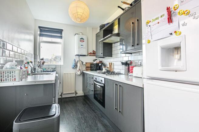 Bright modern galley kitchen with glossy grey c...