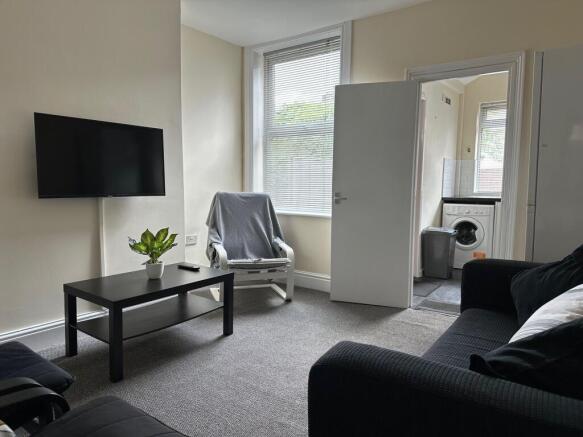 Bright, well-kept living room with a wall-mount...