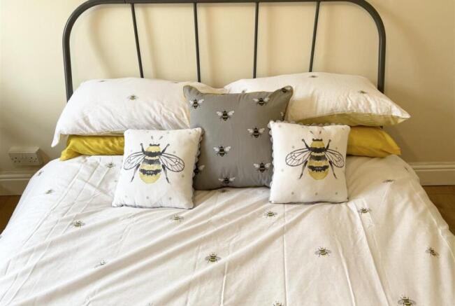Bright, neatly made double bed with a stylish m...