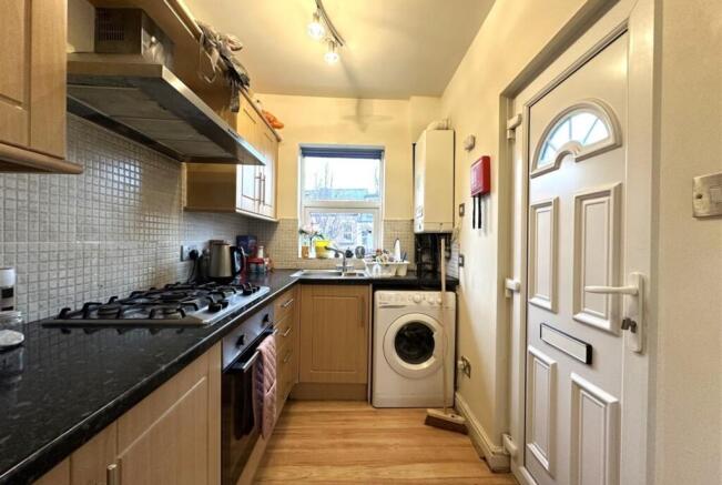 Bright galley kitchen with modern appliances, g...
