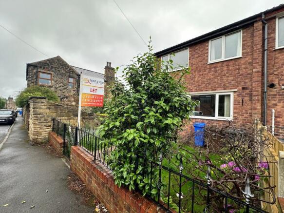 Brick-fronted terraced house with a small fence...