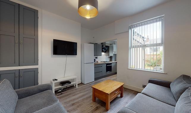 Bright, modern living room with matching grey s...