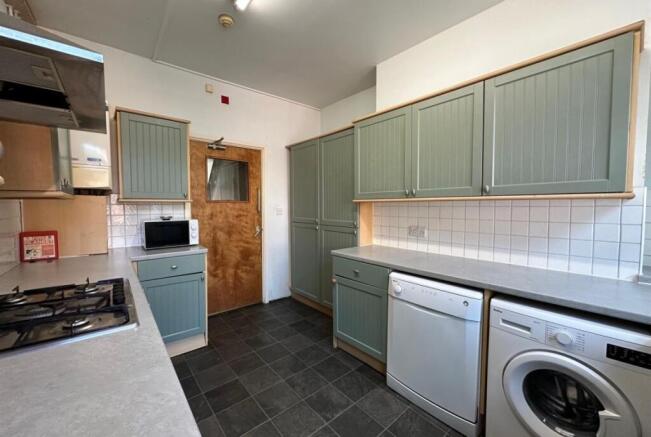 Bright galley-style kitchen with modern sage-gr...