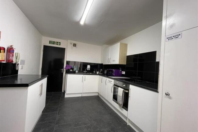 Bright, modern communal kitchen with sleek blac...