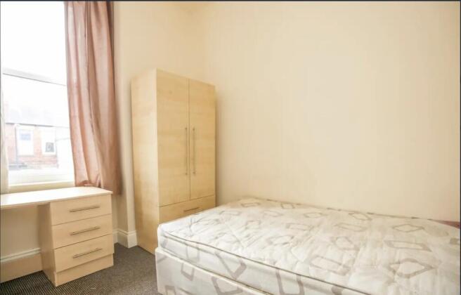 Bright, simply furnished single bedroom with a ...