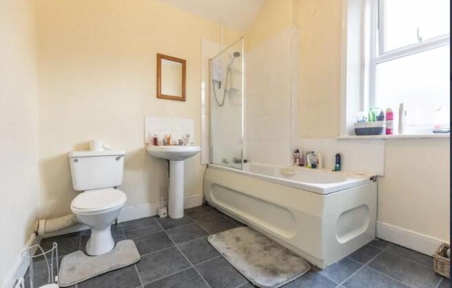 Bright bathroom with a bath and shower screen, ...