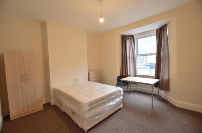 Bright, simply furnished double bedroom with a ...