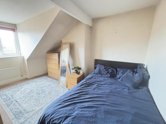 A cozy bedroom featuring a neatly made double b...