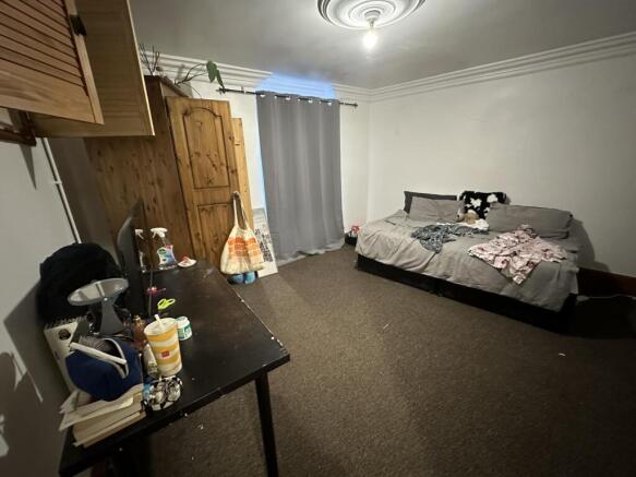 Neat, simply furnished double bedroom with a do...