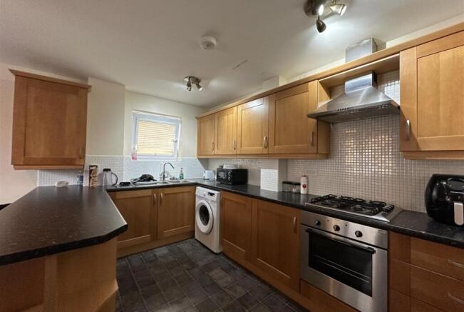 Well-equipped galley kitchen with wooden cabine...
