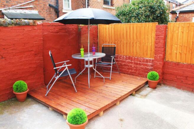 A charming garden area featuring a cozy seating...