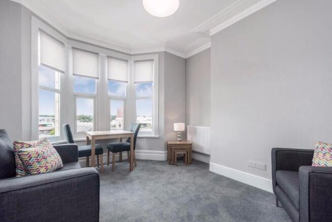 Bright, modern living room with a bay of large ...