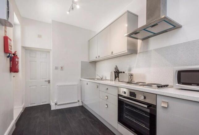 Bright, modern fitted kitchen with gloss cabine...