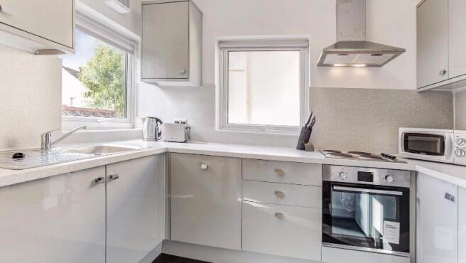 Bright modern kitchen with glossy fitted units,...