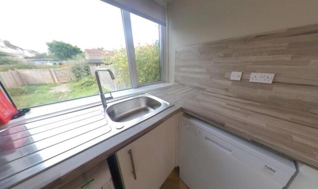 Bright galley-style kitchen with a large window...