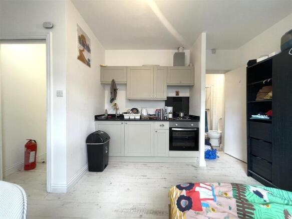 Bright studio room with a compact fitted kitche...