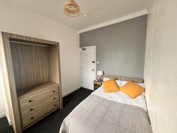 A neat double bedroom featuring a comfortable b...