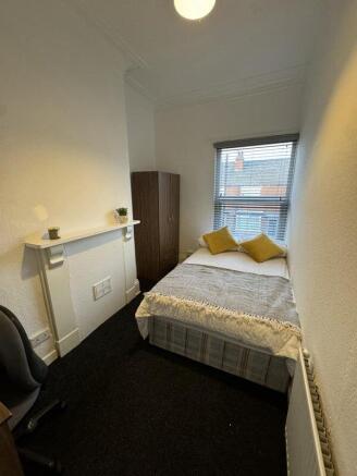 A neat and cozy bedroom featuring a comfortable...