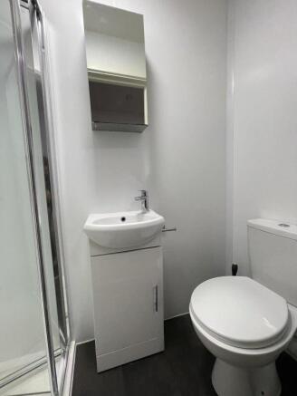 Compact, modern bathroom with a shower cubicle,...