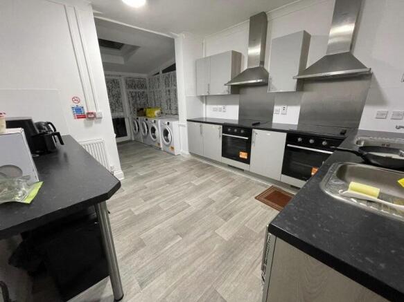 Modern shared kitchen with built-in ovens, stai...