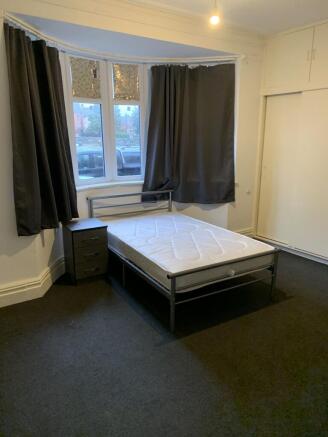 Bright double bedroom with a metal bed frame, b...
