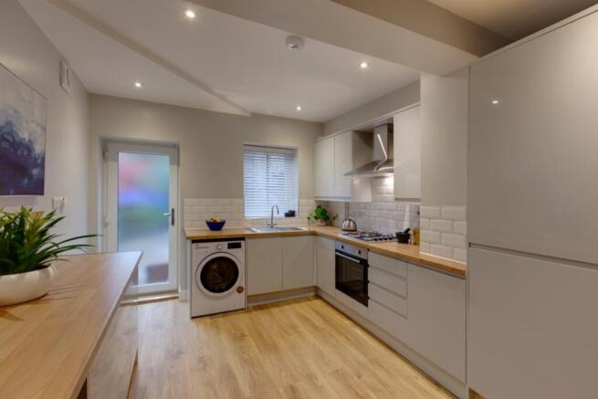 Modern fitted kitchen with light wood worktops,...