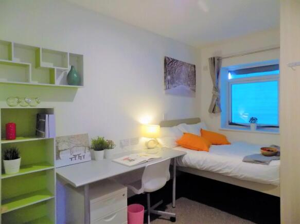 Bright, neatly arranged bedroom with a built-in...