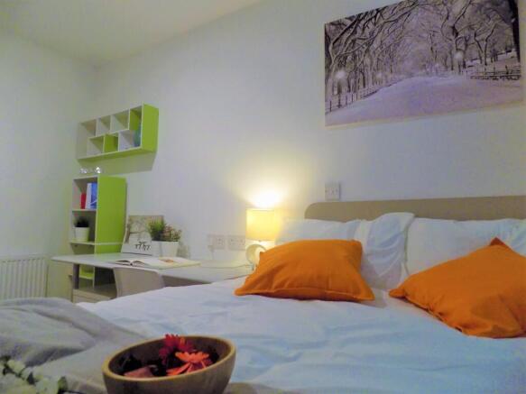 Bright, neatly styled bedroom featuring a comfy...