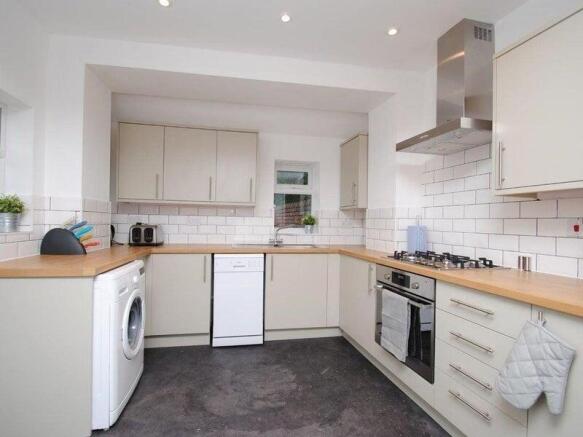 Bright modern kitchen with neutral cabinetry, w...