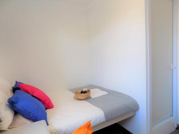 Bright, simply furnished single bedroom with a ...