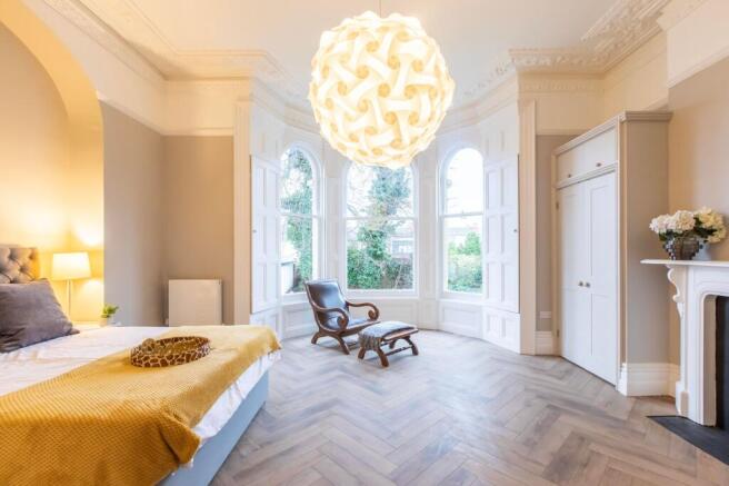 Bright, elegant bedroom with a large bay window...