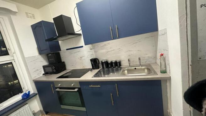 Modern compact kitchen with blue cabinetry, int...