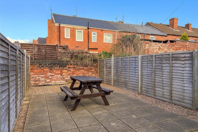 Private paved rear garden with a central picnic...