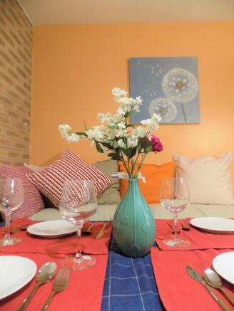 Cozy living area with a neatly set dining table...