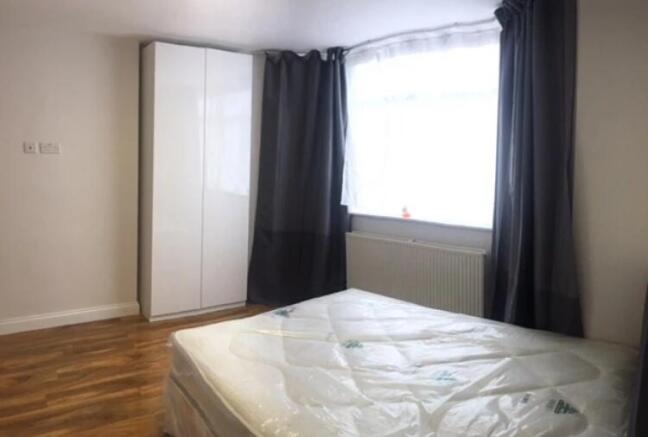 Bright, neatly presented bedroom with a large w...