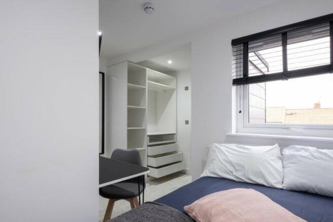 This inviting double bedroom features a cozy be...