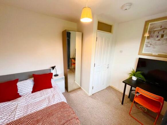This cozy double bedroom features a comfortable...